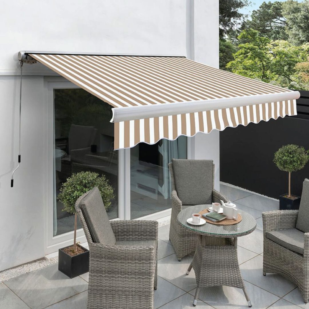 Store banne rayé beige et blanc déployé au-dessus d'une terrasse